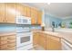 Open kitchen featuring white appliances and light wood cabinets leading to an open floor plan at 1022 Basildon Rd, Mount Pleasant, SC 29466