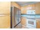 Modern kitchen featuring stainless steel refrigerator and white stove with blonde wood cabinetry at 1022 Basildon Rd, Mount Pleasant, SC 29466