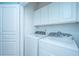 Bright laundry room features new white cabinets and modern, energy-efficient washer and dryer at 1022 Basildon Rd, Mount Pleasant, SC 29466