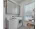 Functional laundry room with modern washer and dryer, storage cabinets, and stylish tile flooring at 1032 Avenue Of Oaks, Charleston, SC 29407