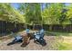 Backyard featuring wooden chairs and a fire pit surrounded by green trees and a black fence at 106 Abigale Ln, Summerville, SC 29483