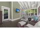 Screened-in porch featuring wicker furniture, light-green walls, and a wall-mounted TV at 106 Abigale Ln, Summerville, SC 29483