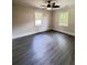 A cozy bedroom with a modern ceiling fan, two windows, and new flooring at 109 Alexander St, Walterboro, SC 29488