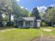 Charming single-story home featuring a brick chimney and inviting front porch, surrounded by mature trees at 109 Alexander St, Walterboro, SC 29488