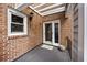 Charming covered back porch with brick walls and a neutral rug at 11 Harleston Pl, Charleston, SC 29401