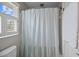 Bright bathroom featuring a shower with stylish curtain, toilet, and window with shutter style shade at 11 Harleston Pl, Charleston, SC 29401
