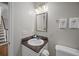 Cozy bathroom featuring a granite-topped vanity, decorative mirror, and adjacent stairway at 11 Harleston Pl, Charleston, SC 29401