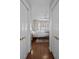 Hallway view into a bedroom with a four-poster bed and bay window with shutter style shades at 11 Harleston Pl, Charleston, SC 29401