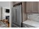 A modern, stainless steel refrigerator is featured next to dark wood cabinets and light-colored stone countertops at 11 Harleston Pl, Charleston, SC 29401