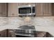 Close up of a sleek kitchen with stainless steel appliances and stone backsplash, great for cooking at 11 Harleston Pl, Charleston, SC 29401