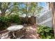 Charming brick patio with mature trees and a round concrete table surrounded by 4 chairs at 11 Harleston Pl, Charleston, SC 29401