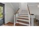 Stairway featuring hardwood steps, white risers, decorative wood banister, and neutral wall color at 11 Harleston Pl, Charleston, SC 29401
