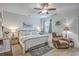 Spacious bedroom with a ceiling fan, a large bed with decorative pillows, and a cozy reading chair at 110 Angelica Ave, Summerville, SC 29483
