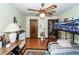 Comfortable bedroom boasts hardwood floors, a ceiling fan, and access to another room at 110 Wallace Rd, Goose Creek, SC 29445