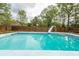 A sparkling in-ground pool featuring a diving board and a wooden privacy fence surrounding it at 110 Wallace Rd, Goose Creek, SC 29445