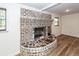 Basement brick fireplace with hearth and wood-look flooring at 115 White Blvd, Summerville, SC 29483