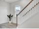 Inviting foyer with a staircase featuring wooden banister and bright white risers, plus a large houseplant at 116 Slater Lake Ln, Summerville, SC 29483