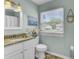 Well-lit bathroom featuring a granite countertop, white vanity, and a window with privacy blinds at 116 Trestlewood Dr, Summerville, SC 29486