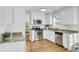 Modern kitchen with stainless steel appliances, white cabinets, and wood floors offers a sleek and functional space at 116 Trestlewood Dr, Summerville, SC 29486