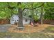 Outdoor living, including a fire pit, seating area, a detached garage and mature trees at 1211 Eastwood Ave, Hanahan, SC 29410