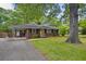 Charming brick home with a well-maintained lawn, mature trees, and a welcoming yellow front door at 1211 Eastwood Ave, Hanahan, SC 29410