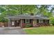 Charming brick home featuring a covered carport, landscaped front yard, and a welcoming yellow front door at 1211 Eastwood Ave, Hanahan, SC 29410
