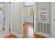 Hallway view showcasing hardwood floors, neutral paint, a bedroom, and the entrance to the black and white tiled bathroom at 1211 Eastwood Ave, Hanahan, SC 29410