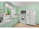 Bright kitchen features white appliances, subway tile backsplash, and light green cabinetry for a vintage look at 1211 Eastwood Ave, Hanahan, SC 29410