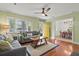 Bright living room features a ceiling fan, hardwood floors, and comfortable grey sofas with backyard view at 1211 Eastwood Ave, Hanahan, SC 29410