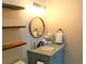 Powder room featuring open shelving, a round wood-trimmed mirror, and gray granite countertop at 126 Jungle Rd # 7B, Edisto Beach, SC 29438