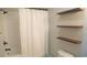 Bathroom featuring a shower with a white curtain and open wooden shelving at 126 Jungle Rd # 7B, Edisto Beach, SC 29438