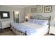 Bright main bedroom with a queen size bed, wood floors, and tasteful artwork at 126 Jungle Rd # 7B, Edisto Beach, SC 29438