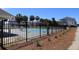 Community pool surrounded by a black fence and greenery at 126 Jungle Rd # 7B, Edisto Beach, SC 29438