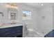 Bright bathroom featuring a shower, and marble countertop sink with wood floors and a window at 13 H St, Charleston, SC 29403