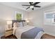 Bright bedroom with wood floors, ceiling fan, two bedside tables, and two windows at 13 H St, Charleston, SC 29403