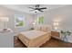 Bright bedroom featuring a ceiling fan, wood floors, two bedside tables, and two windows at 13 H St, Charleston, SC 29403