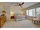 Bright bedroom boasts a ceiling fan, plush carpet, and natural light streaming through large windows at 1307 Ventura Pl, Mount Pleasant, SC 29464