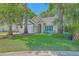 Inviting single-story home with a well-manicured lawn, mature trees, and a cozy seating area on the porch at 1315 Old Mill Ln, Mount Pleasant, SC 29464