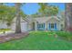 Inviting single-story home with a well-manicured lawn, blue shutters, and cozy seating area on the front porch at 1315 Old Mill Ln, Mount Pleasant, SC 29464
