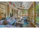 Relaxing screened-in porch with comfortable blue furnishings and bright, colorful decor and view to back yard at 1315 Old Mill Ln, Mount Pleasant, SC 29464