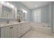 Bathroom featuring a double vanity, neutral paint, and soaking tub, ideal for relaxing at the end of the day at 1339 River Otter Court, Mount Pleasant, SC 29466