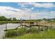 Waterfront dock including covered pier head in a serene, grassy marsh setting with nearby homes at 1339 River Otter Court, Mount Pleasant, SC 29466