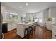 Bright eat-in kitchen with island, granite countertops, hardwood floors, and bay windows showcasing the backyard at 1339 River Otter Court, Mount Pleasant, SC 29466