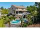 Stunning backyard featuring a pool, palm trees, deck, screened porch, and lush landscaping, creating an inviting outdoor retreat at 1339 River Otter Court, Mount Pleasant, SC 29466