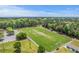 Aerial view of a football field, showcasing the stadium, bleachers, and surrounding green space with ample parking at 134 Comiskey Park Cir, Summerville, SC 29485