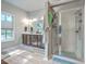 Spacious bathroom with double sinks, walk-in shower, and large window for natural light and ventilation at 134 Comiskey Park Cir, Summerville, SC 29485
