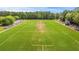 Aerial view of a well-maintained football field surrounded by trees, bleachers, and a bright blue sky above at 134 Comiskey Park Cir, Summerville, SC 29485