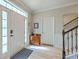 Bright foyer with wood floors, staircase with wrought iron spindles, and decorative accents at 134 Comiskey Park Cir, Summerville, SC 29485
