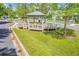 Community gazebo set amidst green lawns provides seating and shade, with a sidewalk and homes nearby at 134 Comiskey Park Cir, Summerville, SC 29485
