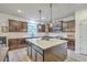 Kitchen with dark wood cabinets, recessed lighting, laminate wood flooring, and a center island with a white countertop at 134 Comiskey Park Cir, Summerville, SC 29485